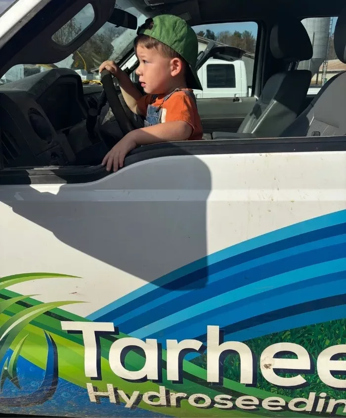 Child sitting in a Tarheel Hydroseeding work truck
